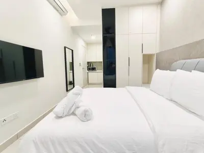 a bedroom with a white bed with a towel on it at KL Premium Dual Key Studio with KLCC view on the 56th floor in Kuala Lumpur