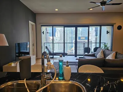 a kitchen with a sink and a living room at Resort Style Haven 3BR6pax St Mary KLCC Twin Towers View in Kuala Lumpur