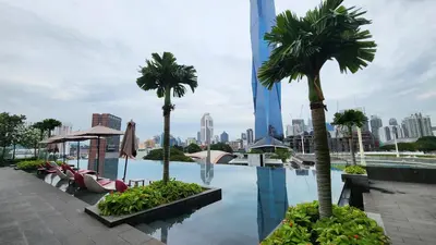 a pool with palm trees on the roof of a building at Opus Residences Kuala Lumpur by Infini Suites in Kuala Lumpur