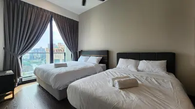 two beds in a hotel room with a window at Opus Residences Kuala Lumpur by Infini Suites in Kuala Lumpur