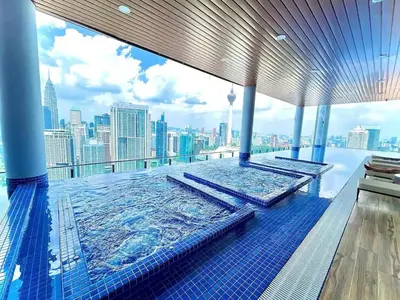 a pool on the top of a building with a city skyline at Maxhome Cozy at The Luxe in Kuala Lumpur