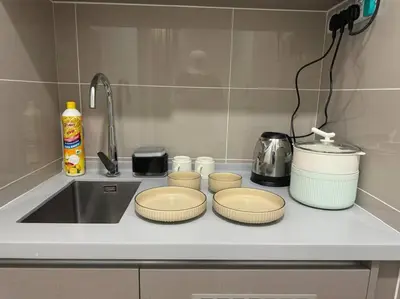 a kitchen counter with three stools on top of it at TRION KL, KLCC TRX IKEA at Chan Sow Lin, Kuala Lumpur by ONE Guesthouse in Kuala Lumpur