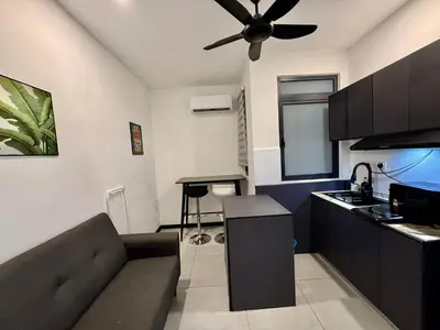 a kitchen and living room with a couch and a ceiling fan at Neu Suites Service Apartment By Moonlight in Kuala Lumpur