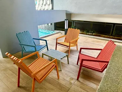 four colorful chairs and a table on a patio at Neu Suites Service Apartment By Moonlight in Kuala Lumpur