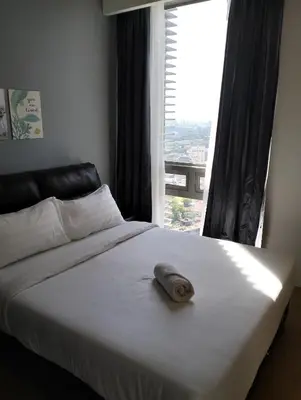 a bed with a pillow on it in front of a window at Star Suites At Swiss Garden Residences in Kuala Lumpur