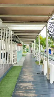 a row of white tables and chairs on a walkway at Immersed in the warmth and natural ambience in Kuala Lumpur
