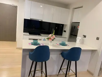 a kitchen with two blue chairs at a kitchen counter at Holiday Suites Star Residences in Kuala Lumpur
