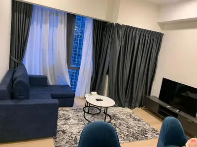 a living room with a blue couch and a table at Holiday Suites Star Residences in Kuala Lumpur