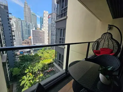 a balcony with a table and a view of a city at City Vibe Oasis St Mary Pavilion KLCC 3Bed6pax in Kuala Lumpur