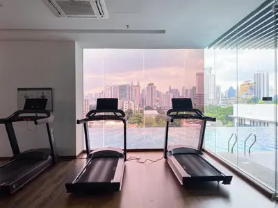 a gym with two treadmills in front of a large window at 2B2B Cozy - 5 min to PWTC - Sentul KL in Kuala Lumpur
