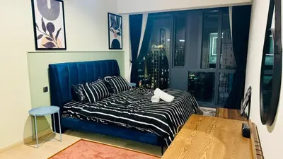 a bedroom with a blue couch and a window at Star KLCC by homestay in Kuala Lumpur