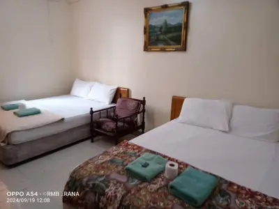a room with two beds and a chair in it at perfect class hotel in Kuala Lumpur