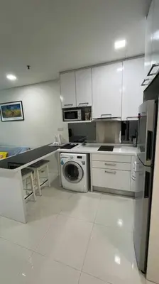 a kitchen with white cabinets and a washing machine at KL City Centre in Kuala Lumpur