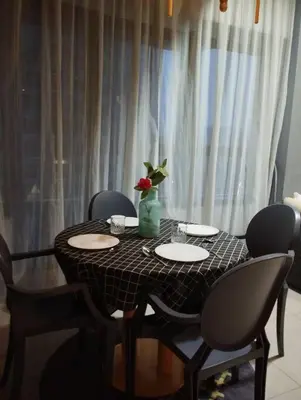 a black table with chairs and a vase with a flower on it at apartment for classic lover in Kuala Lumpur