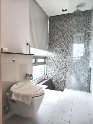 a bathroom with a toilet and a glass shower at Swiss Garden Residence by Offex Suites KL in Kuala Lumpur