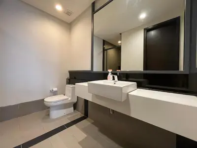 a bathroom with a toilet and a sink and a mirror at The Mews KLCC by PILLOWTALKS in Kuala Lumpur