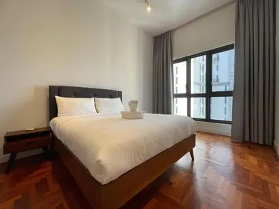 a bedroom with a large bed and a large window at The Mews KLCC by PILLOWTALKS in Kuala Lumpur