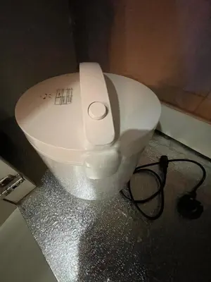 a white toilet in a bathroom with a charger at cozy 3 bedroom 6PAX setapak central mall in Kuala Lumpur