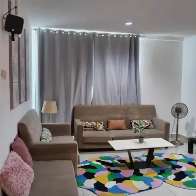 a living room with a couch and a table at Cozy lake view at top of setapak central mall in Kuala Lumpur