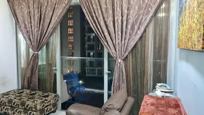 a living room with a couch and a window with a view at Hostel At Regalia Residence in Kuala Lumpur