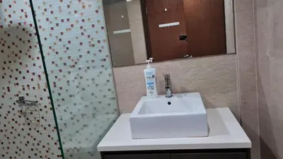 a bathroom with a white sink and a shower at Hostel At Regalia Residence in Kuala Lumpur