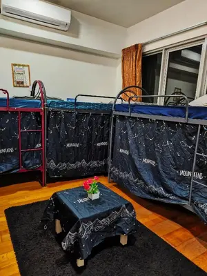 a room with two bunk beds and a table with flowers on it at Casablanca Skypool Hostel in Kuala Lumpur