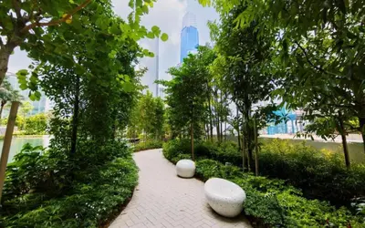 a walkway in a park with benches and trees at AGILE Bukit Bintang By Irent365 in Kuala Lumpur