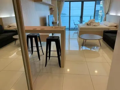 a living room with a table and two stools at Bmchomes Mercu summer suite in Kuala Lumpur