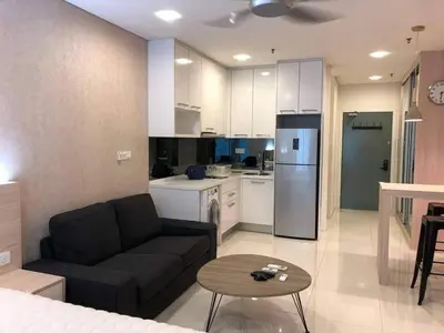 a living room with a couch and a kitchen at Bmchomes Mercu summer suite in Kuala Lumpur