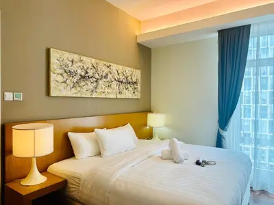 a bedroom with a large bed with a white blanket at SOHO SUITES KLCC by DREAMS in Kuala Lumpur