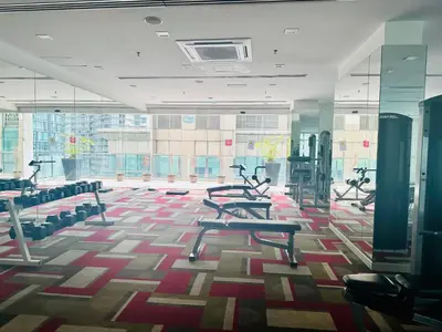 a gym with treadmills and ellipticals in a building at SOHO SUITES KLCC by DREAMS in Kuala Lumpur