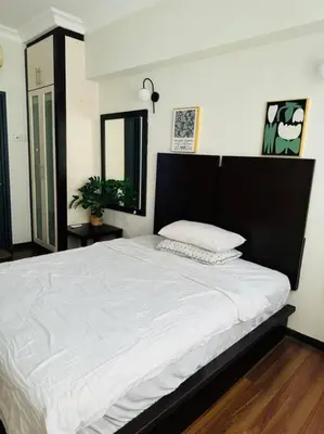 a bedroom with a large white bed with a black headboard at Luxury Room Minutes from KLCC in Kuala Lumpur
