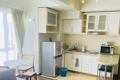 a kitchen with a refrigerator and a table with chairs at Luxury Room Minutes from KLCC in Kuala Lumpur