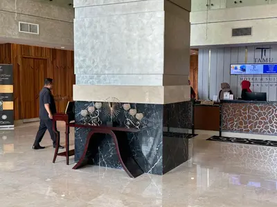 a man walking through a lobby with a table at Tamu Hotel & Suites Stay in Kuala Lumpur
