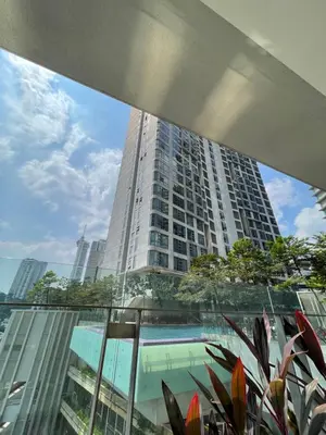 a view of a tall building from a glass balcony at The Robertson Residence Kuala Lumpur in Kuala Lumpur