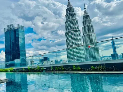 a view of the petronas twin towers from a swimming pool at Star Residence KLCC By Starlight in Kuala Lumpur