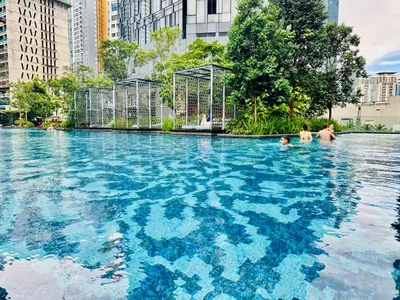 a swimming pool with blue water in a city at Star Residence KLCC By Starlight in Kuala Lumpur