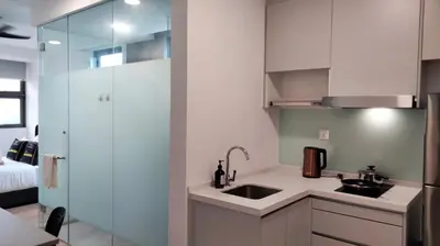 a small kitchen with a sink and a shower at Riveria Suites, KL Sentral by Homebrickz in Kuala Lumpur