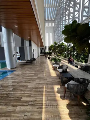 a hallway with benches and plants in a building at THE COLONY INFINITUM Sweet Home SR in Kuala Lumpur
