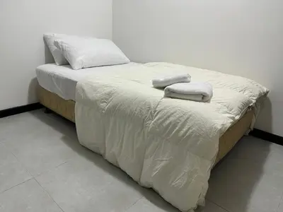 a white bed with two towels on top of it at KL City Nue Suites Entire Condo 2R2B 3 plus 1 guests in Kuala Lumpur