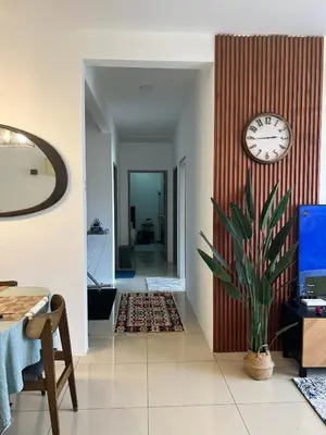 a living room with a clock on a wall at Casa Dbandar in Kuala Lumpur