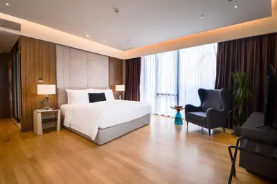 a bedroom with a bed and a chair and a television at Imperial KLCC by Opus Hospitality in Kuala Lumpur