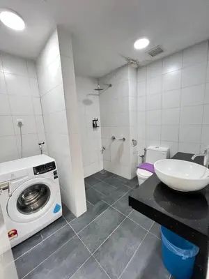 a bathroom with a washing machine and a sink at Chambers Skylight Sernity Suites KLCC in Kuala Lumpur