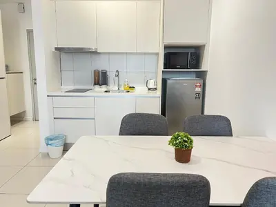 a kitchen with a table and chairs and a refrigerator at Chambers Skylight Sernity Suites KLCC in Kuala Lumpur