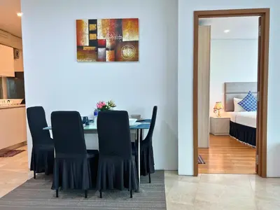 a dining room with a table and chairs and a bed at Vortex Apartments Kuala Lumpur in Kuala Lumpur