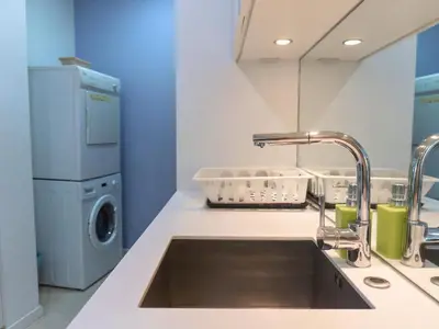 a kitchen with a sink and a washing machine at Vortex Apartments Kuala Lumpur in Kuala Lumpur