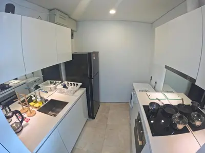 a kitchen with white cabinets and a stove top oven at Vortex Apartments Kuala Lumpur in Kuala Lumpur