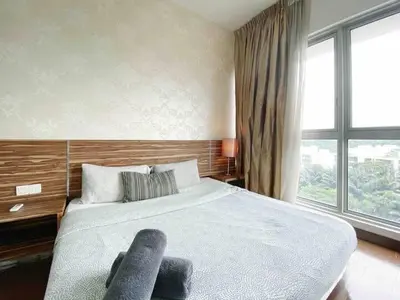 a bedroom with a large bed and a large window at Regalia by sweet home in Kuala Lumpur