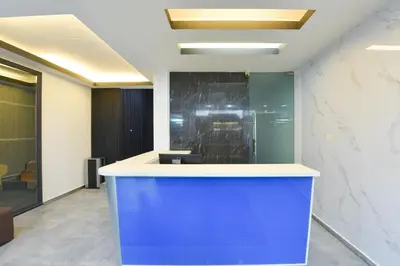 an office lobby with a blue island in the middle at Hotel O Pollodium Chinatown in Kuala Lumpur
