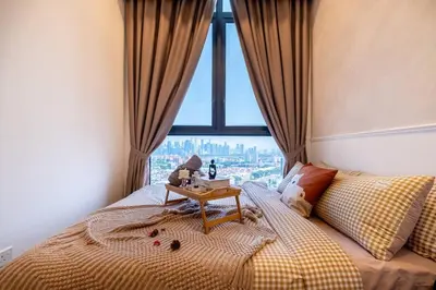 a bedroom with a bed with a table on it at KidsVille Shamelin Star KLCC View Infinity Pool in Kuala Lumpur